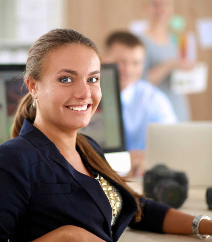 young woman working in office, sitting at desk