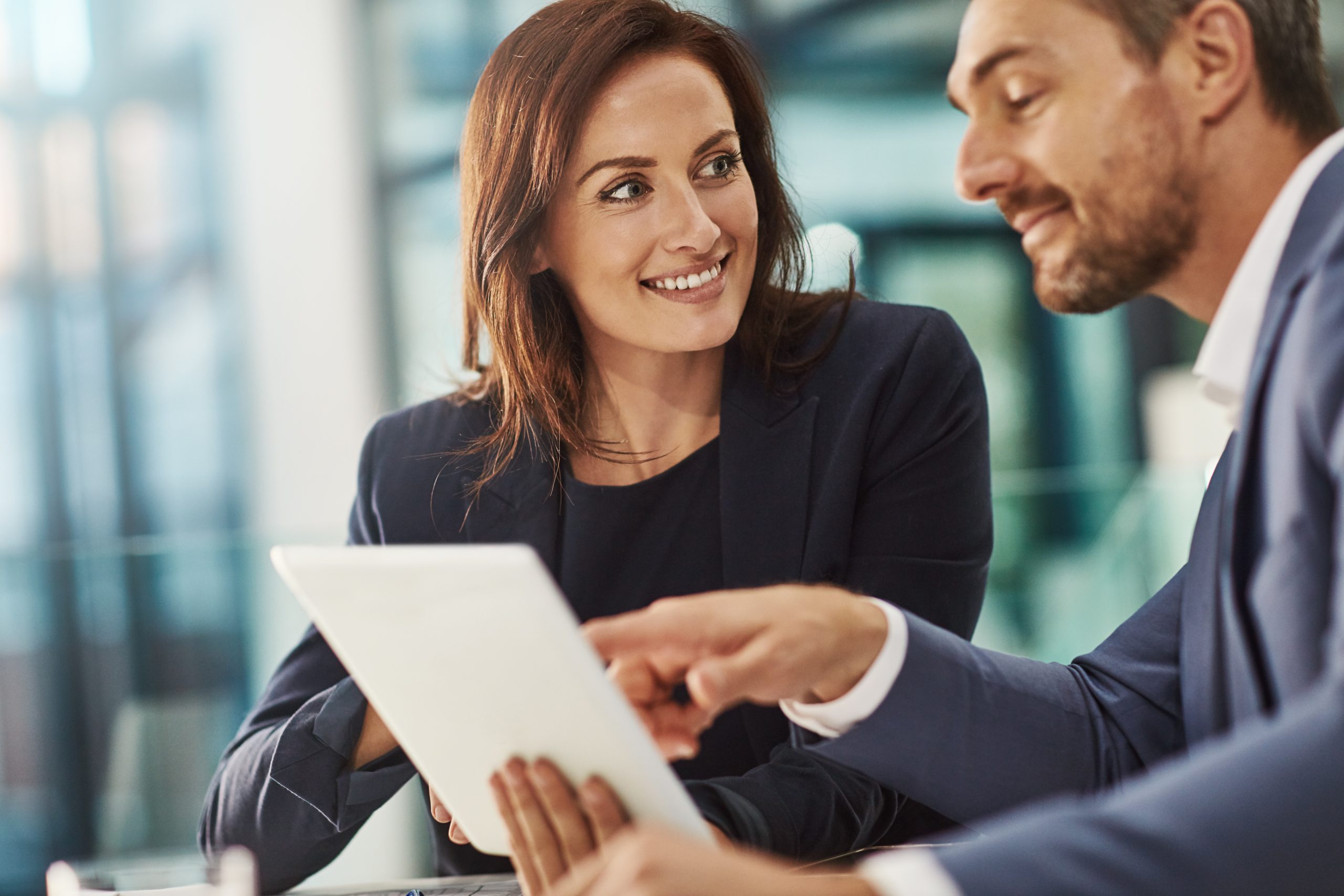 training, coaching and business people with tablet in office workplace. collaboration, mentor and woman and man pointing at touchscreen technology planning sales, financial or research and strategy.